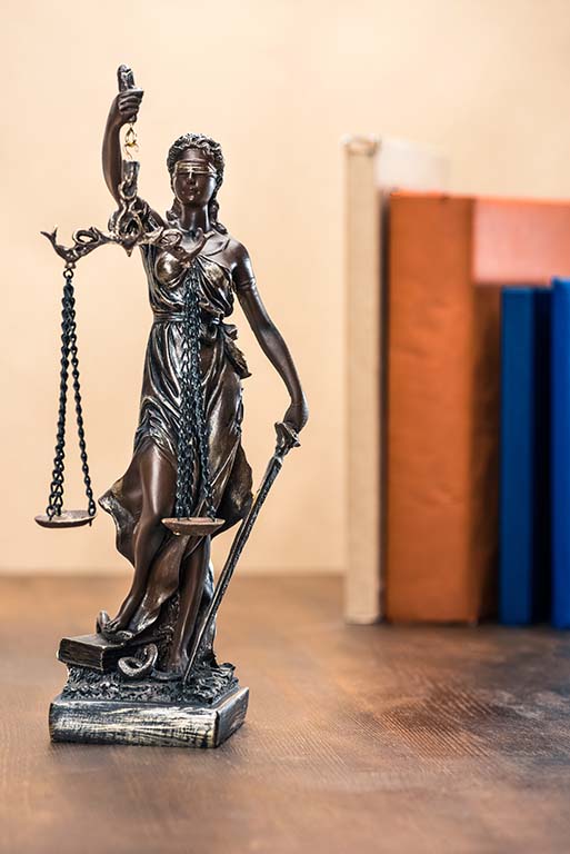 Close-up view of statue of lady justice on wooden table, Law con